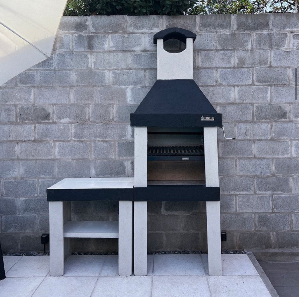 Argentine Grill ECO Mini installed on a patio, with a separate countertop